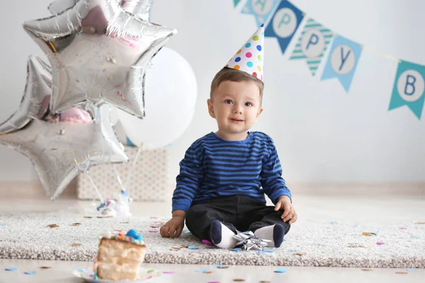 誕生日パーティーのための部屋のカーペットの上に座ってかわいい男の子 — ストック写真