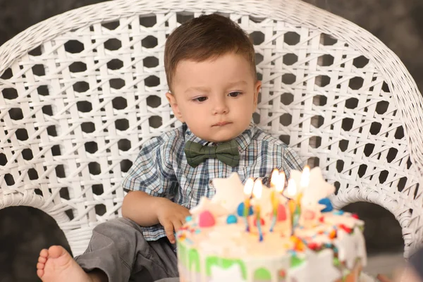 部屋の肘掛け椅子に座って誕生日ケーキとかわいい男の子 — ストック写真