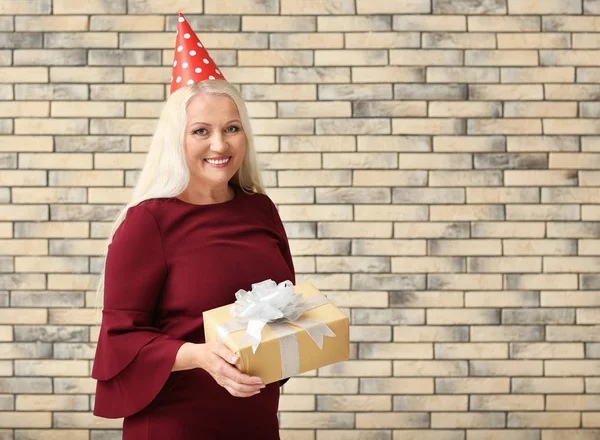 Mulher Madura Com Presente Aniversário Fundo Parede Tijolo — Fotografia de Stock