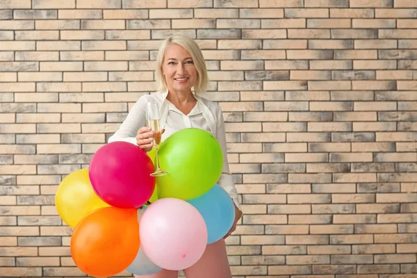 Mature Woman Bright Balloons Glass Champagne Brick Wall Background Birthday — Stock Photo, Image