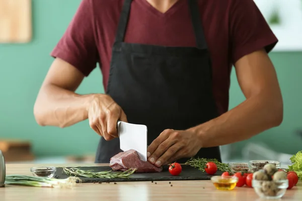 Man Cutting Raw Meat Slate Plate Kitchen — Stock Photo, Image