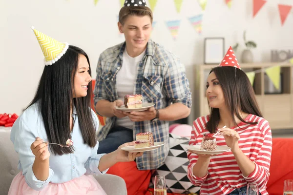 若い人は屋内での誕生日パーティーで食べるおいしいケーキ — ストック写真
