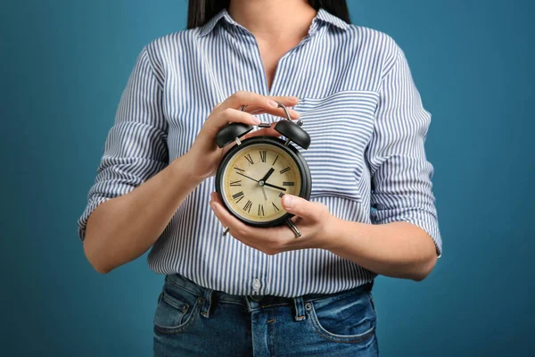 色の背景上の目覚まし時計を保持している女性 時間管理の概念 — ストック写真