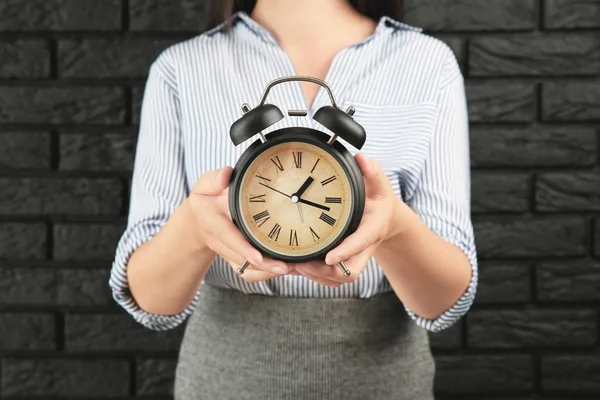 Vrouw Met Alarm Klok Tegen Een Bakstenen Muur Time Management — Stockfoto