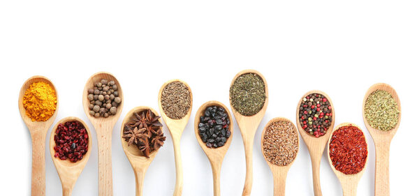 Spoons with different dry spices on white background