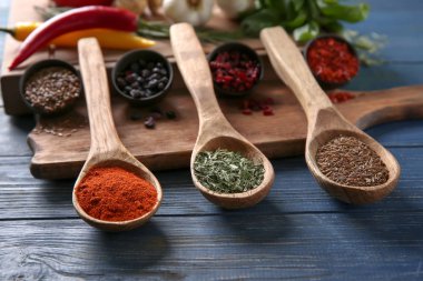 Ahşap masa üzerinde farklı baharatlar kaşıklarla