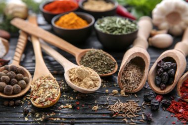 Kaşık ve ahşap arka plan üzerinde farklı baharatlar ile kaşık toz