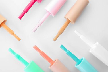 Beyaz arka plan üzerinde renkli tırnak cilaları gövdeli lineer fırçalar