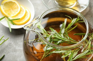 Cam çaydanlık gri tablo içinde taze biberiye ile sıcak çay