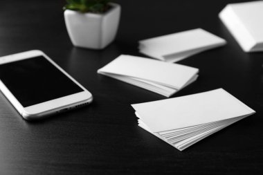 Karanlık tablo üstünde hareket eden telefon ile boş kartvizit