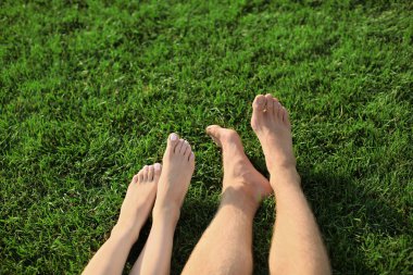 Genç çift açık havada yeşil çim üzerinde yalan