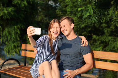 Genç çift alarak selfie Park güneşli