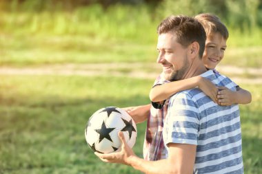 Baba ve oğul ile topu parkta oynarken