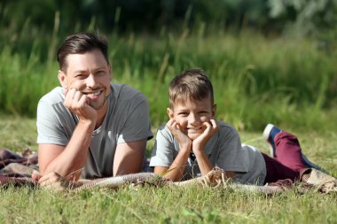 Adam küçük oğluyla Park'ta dinlenme