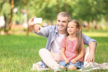 Mutlu baba ve kızı alarak selfie yeşil park