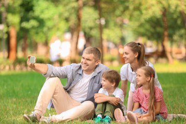 Mutlu aile alarak selfie yeşil park