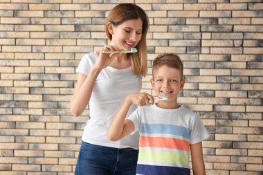 Kadın ve küçük oğlu duvara karşı diş fırçalama