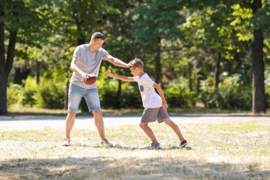 Açık havada Ragbi oynarken babası olan küçük çocuk