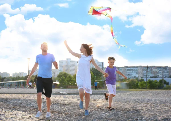 快乐的家庭与风筝在海滩上 — 图库照片