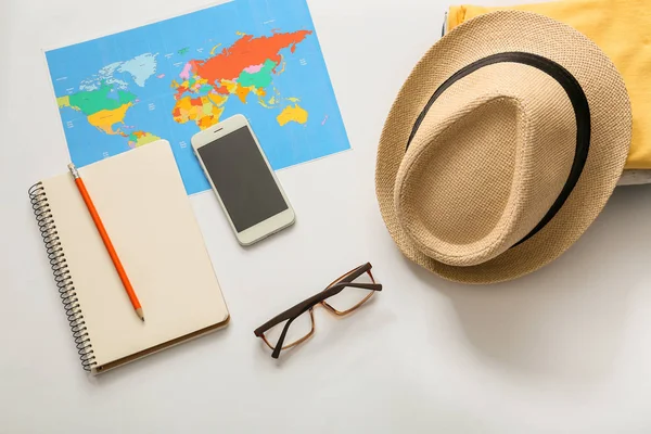 世界地図 携帯電話 服や白い背景の上のアクセサリーで構成 旅行の計画 — ストック写真