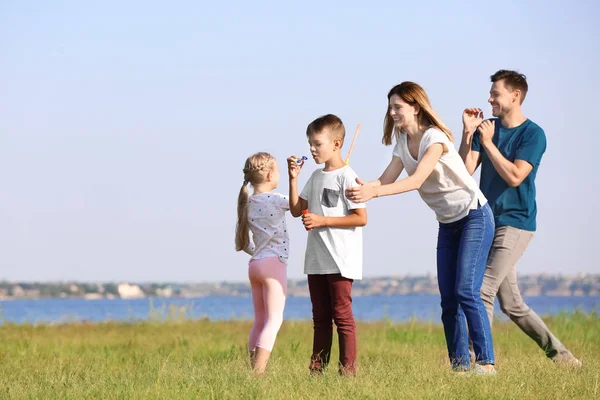 Family Blowing Soap Bubbles River Summer Day — Stock Photo, Image