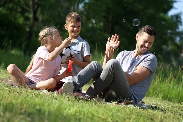 Hombre Con Sus Hijos Pequeños Soplando Burbujas Jabón Parque —  Fotos de Stock