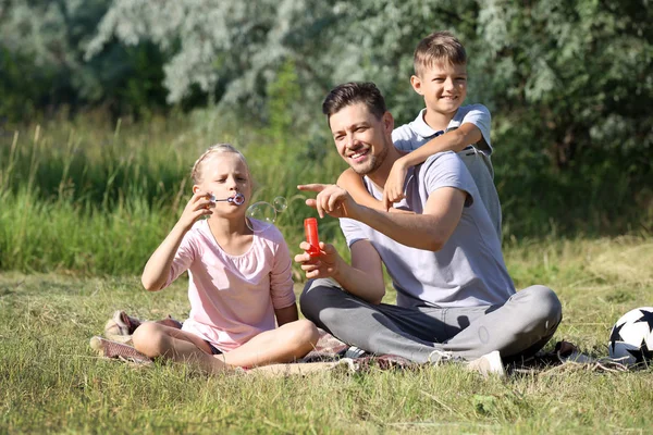 Hombre Con Sus Hijos Pequeños Soplando Burbujas Jabón Parque — Foto de Stock