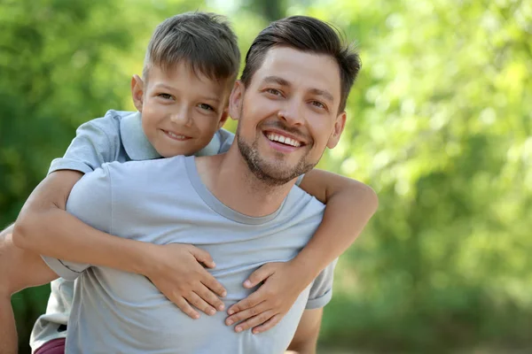 Happy man with his little son in park