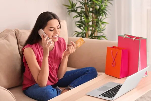 Jovem Com Cartão Crédito Falando Celular Casa Compras Online — Fotografia de Stock
