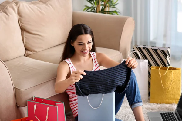 Young Woman Taking Clothes Out Shopping Bag Home — Stock Photo, Image