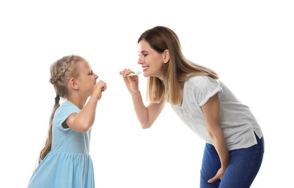 可爱的小女孩和她的母亲在白色背景上刷牙 — 图库照片