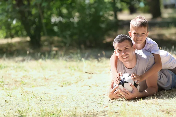 Malý Chlapec Jeho Otec Fotbalovým Míčem Ležící Trávě Venku — Stock fotografie