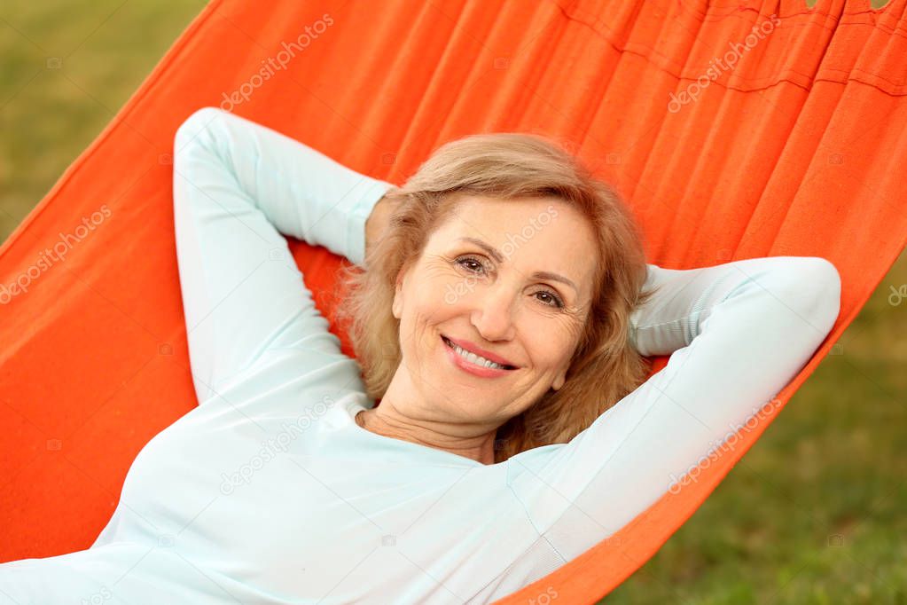 Mature woman resting in hammock outdoors