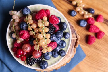 Ahşap masa üzerinde farklı Olgun meyveleri ile plaka