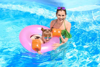 Mutlu anne ve kızı yüzme havuzunda şişme yüzüklü