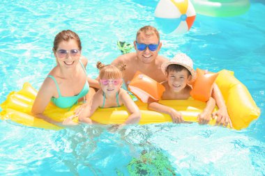 Mutlu aile ile yüzme havuzunda şişme yatak