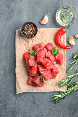 Taze çiğ et baharatlar, otlar ve yağ ile gri dokulu arka plan üzerinde kesmek.