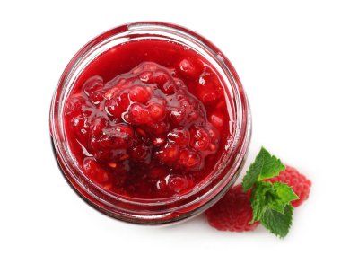 Beyaz zemin üzerinde ahududu reçeli olan cam kavanoz