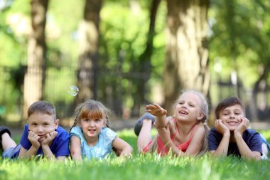Sevimli küçük çocuk parkı yeşil çim üzerinde yalan
