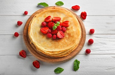 Kurulu krep ve ahşap masa üzerinde çilek ile