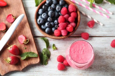 Lezzetli ahududu güler yüzlü ve ahşap masa üzerinde meyveleri ile cam