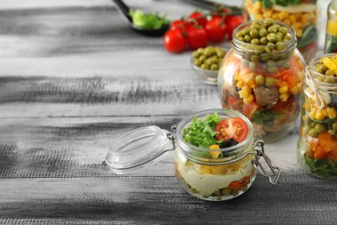 Ahşap masa üzerinde mason kavanoz lezzetli sebze salatalar