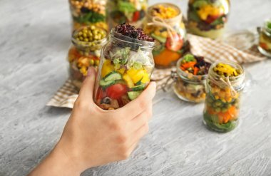 Mason kavanoz sebze salatası ile tutan kadın