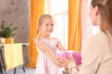 Sevimli küçük kız annesi evde anneler günü için hediye kutusu veren