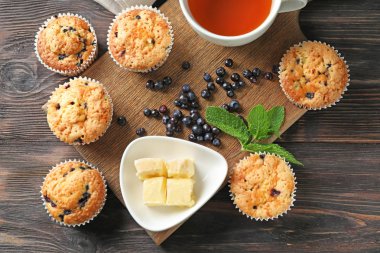 Lezzetli blueberry muffins tereyağı ve ahşap masa üzerinde çay ile