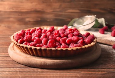 Ahşap arka plan üzerinde taze ahududu ile lezzetli pasta