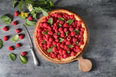 Gri arka plan üzerinde taze ahududu ile lezzetli pasta
