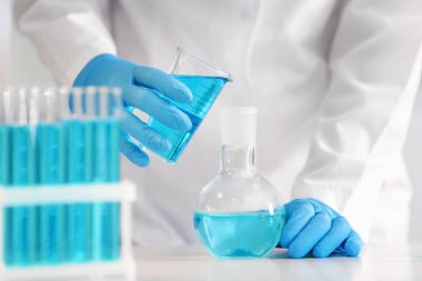 Laboratuvar şişesi içine renk sıvı dökme bilim adamı