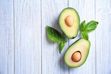 Beyaz ahşap arka plan üzerinde olgunlaşmış avokado kesilmiş taze