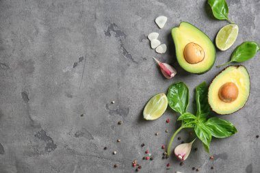 Gri dokulu arka plan üzerinde taze olgun avokado ile kompozisyon